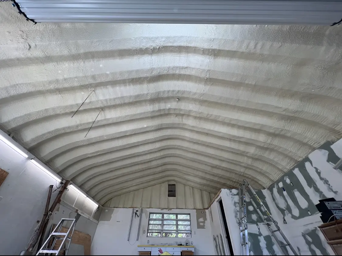 Spray polyurethane foam applied to the underside of a metal roof deck in Upper